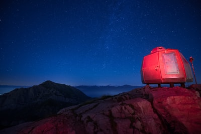 岩石顶上的灰色活动房屋，天上有星星